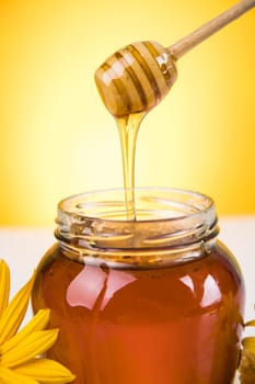 Honey jar, flower with dipper and flowing honey