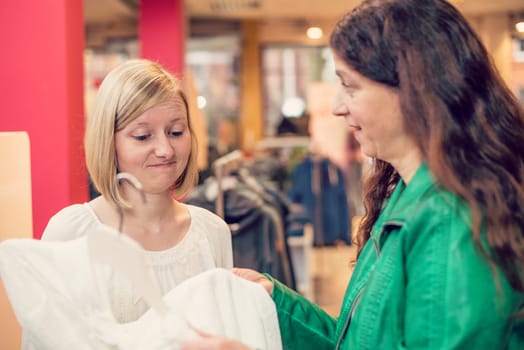 two women in the clothes shop looking for outfit