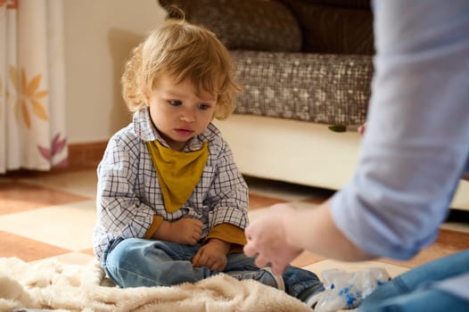 A mother engaging with her young son while spending quality time together at home, promoting a warm and emotional family bond.