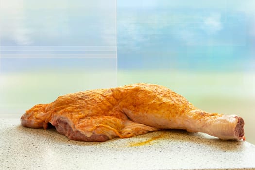 Raw turkey leg or drumstick with spice on table over bright backround. Preparation before cooking. Concept food.
