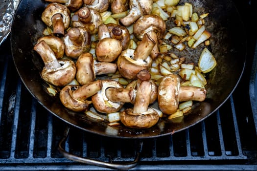 a lot of grilled mushrooms in pan on barbecue
