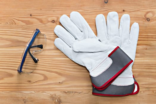 goggles and work gloves on wooden ground