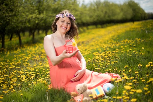 Home, pregnant woman in the meadow