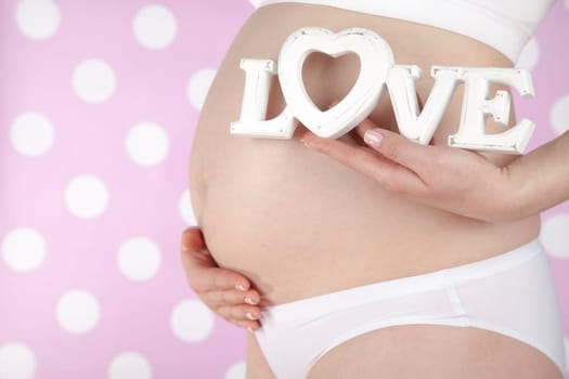 Pregnant woman holding a heart