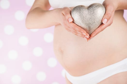 Pregnant woman holding a heart
