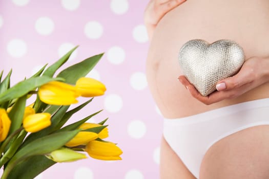Pregnant woman holding a heart