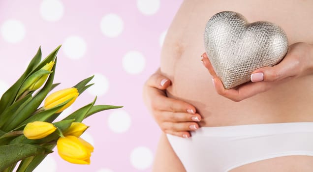 Pregnant woman holding a heart