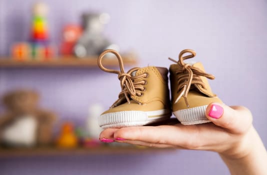Pregnant woman holding baby shoes in her hands