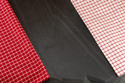 Red and white checkered tablecloth on massive slate plate. Template for design menu card and chalkboard. Space for designer.