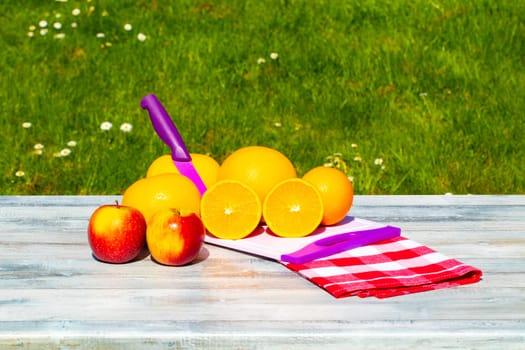 A stack of grapefruits and apples on rustic bright table with natural green background. Concept Health.