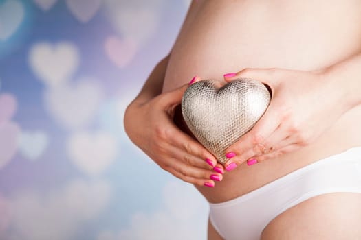 Pregnant woman holding a heart