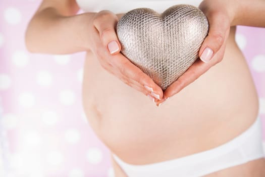 Pregnant woman holding a heart