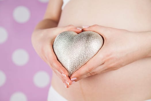 Pregnant woman holding a heart