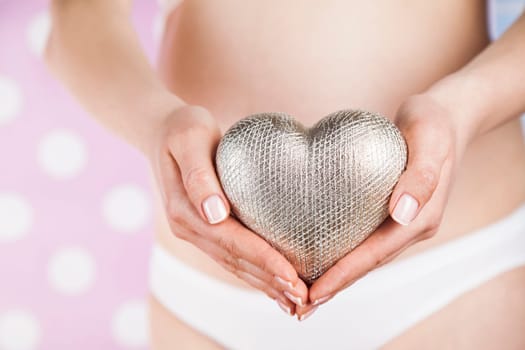 Pregnant woman holding a heart