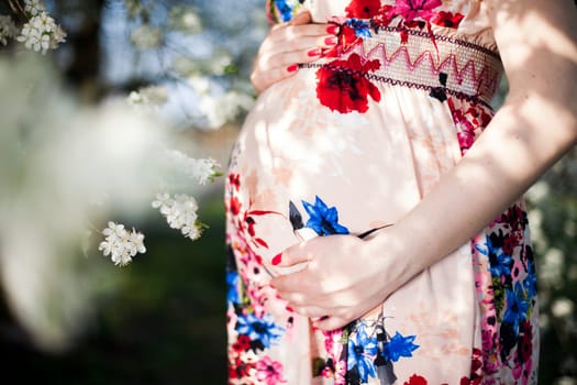 Beautiful pregnant woman relaxing outside in the Orchard