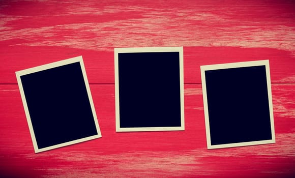Vintage photo frames on a rustic red wooden background