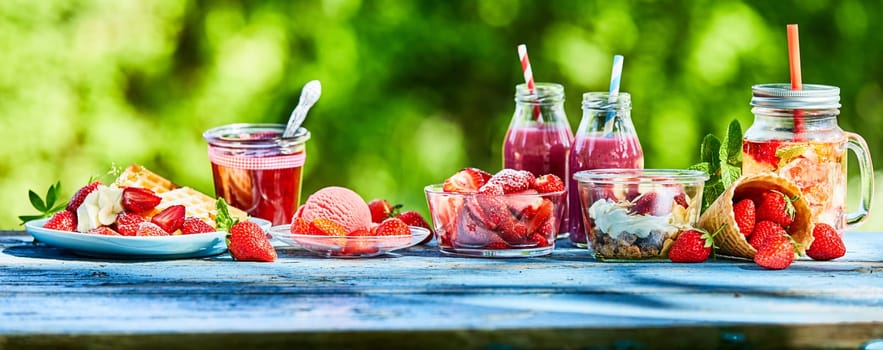 Summer strawberry garden food panorama banner. Delicious berry menus and desserts, punch bowl and ice cream and smoothies outdoors for advertising.