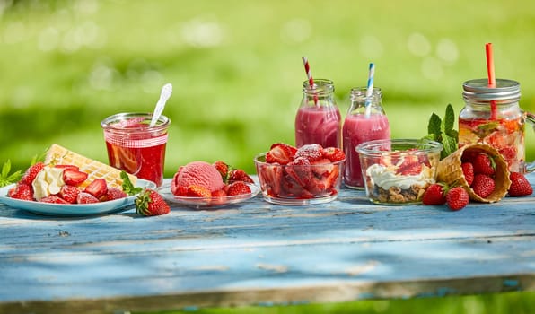 Fresh, sweet, healthy summer berry menus, smoothie bowls and juices on a bright outdoor table setting in a panoramic aspect ratio.