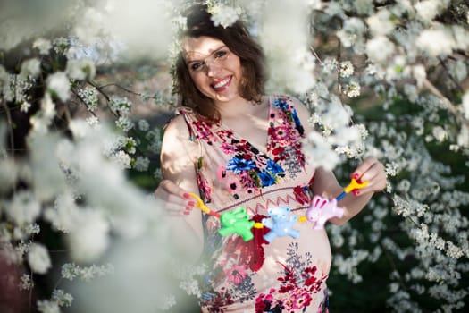 Young beautiful pregnant woman, blooming garden