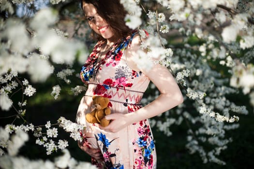 Beautiful pregnant woman relaxing outside in the Orchard