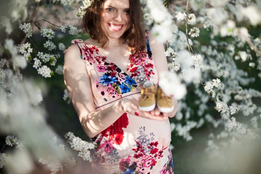 Beautiful pregnant woman relaxing outside in the Orchard