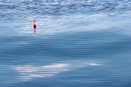 Fishing float on the water with waves and beautiful reflection