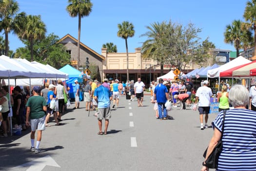 The Villages, FL, USA -April 1, 2017: Farmer’s market near Paddock Square. People shop from various Farmer’s Market sellers outdoors. Many mature people peruse various shops at outside market