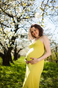 Beautiful pregnant woman relaxing outside in the Orchard