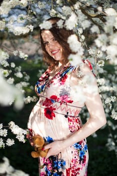 Beautiful pregnant woman relaxing outside in the Orchard