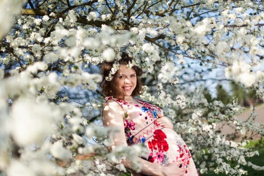 Beautiful pregnant woman relaxing outside in the Orchard