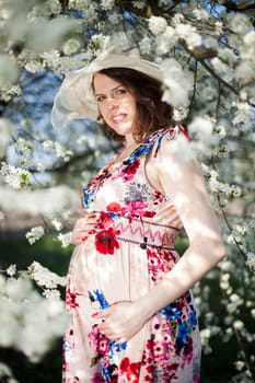 Beautiful pregnant woman relaxing outside in the Orchard