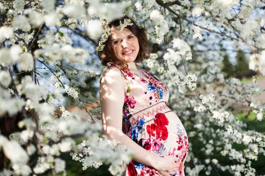 Beautiful pregnant woman relaxing outside in the Orchard