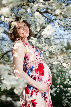 Beautiful pregnant woman relaxing outside in the Orchard