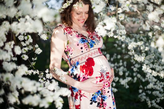 Beautiful pregnant woman relaxing outside in the Orchard