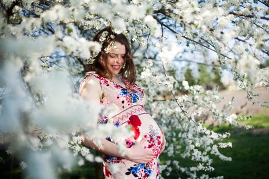 Beautiful pregnant woman relaxing outside in the Orchard