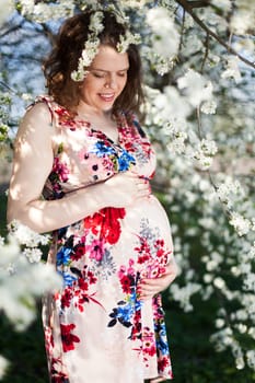 Spring, Young beautiful pregnant woman in the Orchard