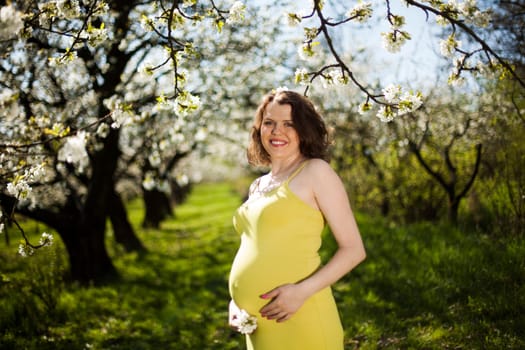 Beautiful pregnant woman relaxing outside in the Orchard