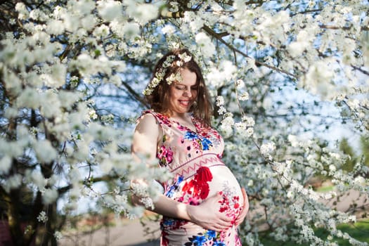 Beautiful pregnant woman relaxing outside in the Orchard