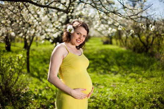 Spring, Young beautiful pregnant woman in the Orchard