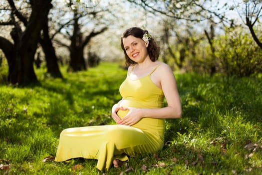 Beautiful pregnant woman relaxing outside in the Orchard