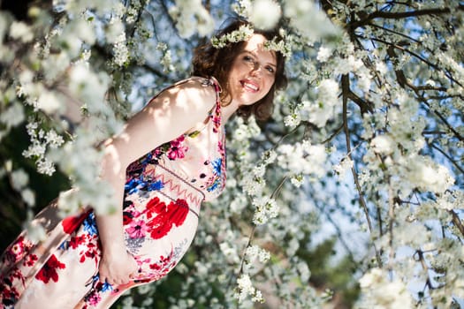 Young beautiful pregnant woman, blooming garden