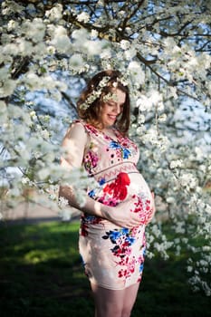 Spring, Young beautiful pregnant woman in the Orchard