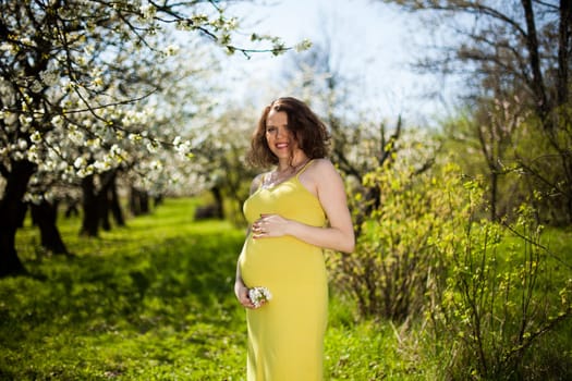 Beautiful pregnant woman relaxing outside in the Orchard