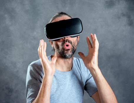 young man with virtual reality glasses looking surprised