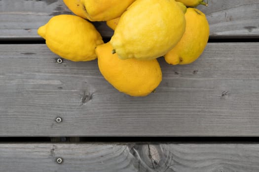 pile of yellow lemons on wooden ground