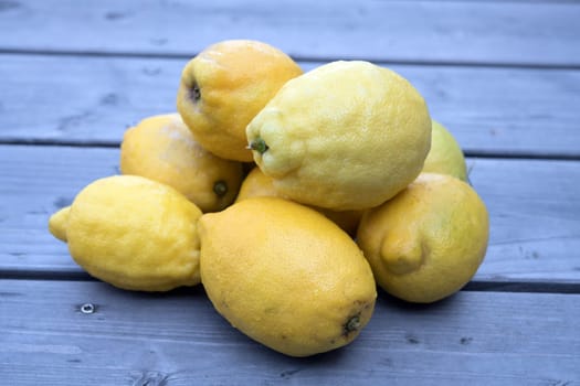 pile of yellow lemons on wooden ground
