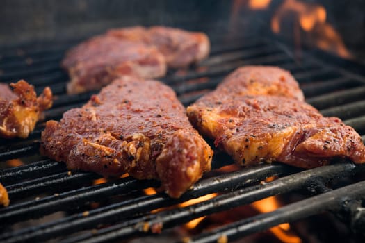 grilled pork with flames on charcoal barbecue