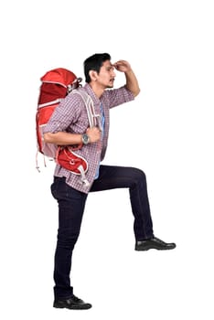 Side view of asian backpacker looking at view standing isolated over white background