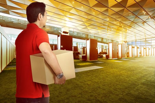 Attractive asian delivery man bring package to deliver on modern building