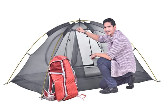 Portrait of asian backpacker man prepare the tent posing isolated over white background